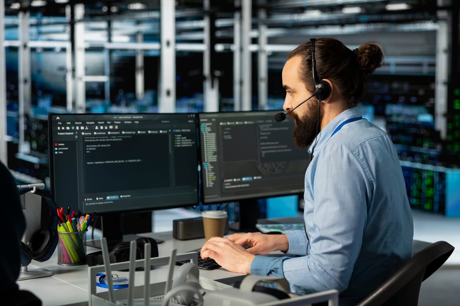 Mitarbeiter mit Headset betreut Anfragen an zwei Bildschirmen
