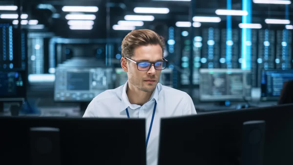 Systemadministrator prüft Systemmeldungen an zwei Bildschirmen